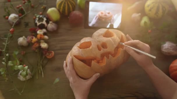Strašidelná Dýně Halloween Samice Vyřezává Halloweenskou Výzdobu Pomocí Tabletu Vrchol — Stock video