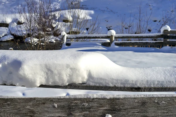 チロル アルプス冬の風景 木製の柵を雪に覆われた 山の背景に小さな川 — ストック写真