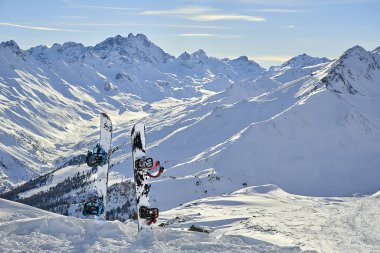 Güneş gün arka planda dağlar arasında devreden yamacında karda snowboard 