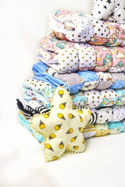 patchwork ve moda kavramı - güzel renkli yorgan, yatak örtüleri Muhafazası, beyaz zemin üzerine dikişli ürünlerin satışı için yükseklik içinde birkaç satır içinde yığılmış yığını