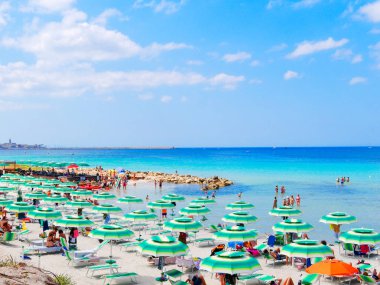 Güzel plaj ve deniz Alghero'da görünümünü. Beach-goers şezlong üzerinde Kiralama. Sardunya, İtalya.
