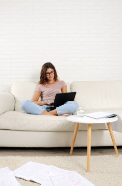 evde laptop ve Not yastıkları ile okuyan kız