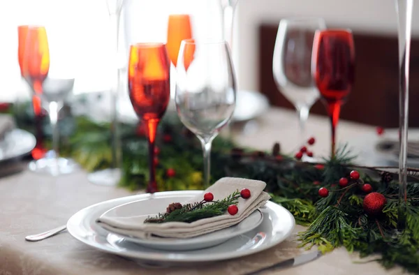 带红色眼镜和绿色树枝的圣诞餐桌设置 — 图库照片