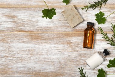 Ahşap arka planda yaprakları olan güzellik ürünleri çerçevesi