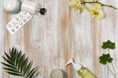 Orkide ve ahşap arka planda yapraklarla güzellik ürünleri çerçevesi