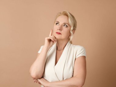 Bej arka planda endişeli güzel bir kadının portresi