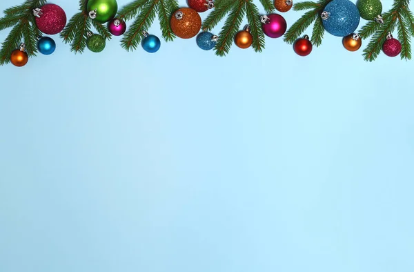 蓝色背景的冷杉树枝和彩色灌木的圣诞框架 — 图库照片