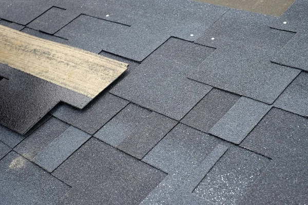 Installing asphalt roofing shingles. Installation of waterproofing coating in construction.