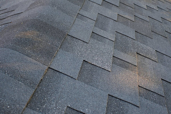 Close up top view on corner roof made is asphalt roofing shingles