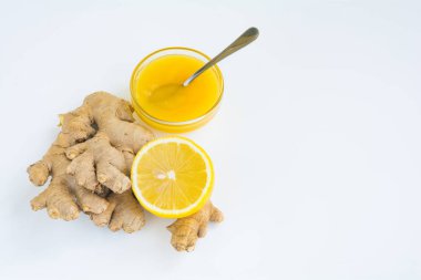 Zencefil, limon ve beyaz zemin üzerine bal ile doğal çay için malzemeler. Sağlıklı içecek. Sıcak kış içecek.