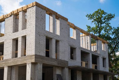 Bir tuğla çok katlı Mavi gökyüzüne karşı bina inşaatı.