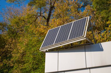 Bir güneş paneli üstte, mavi gökyüzü ve sonbahar arka plan ile bir bina çatı Close-up.