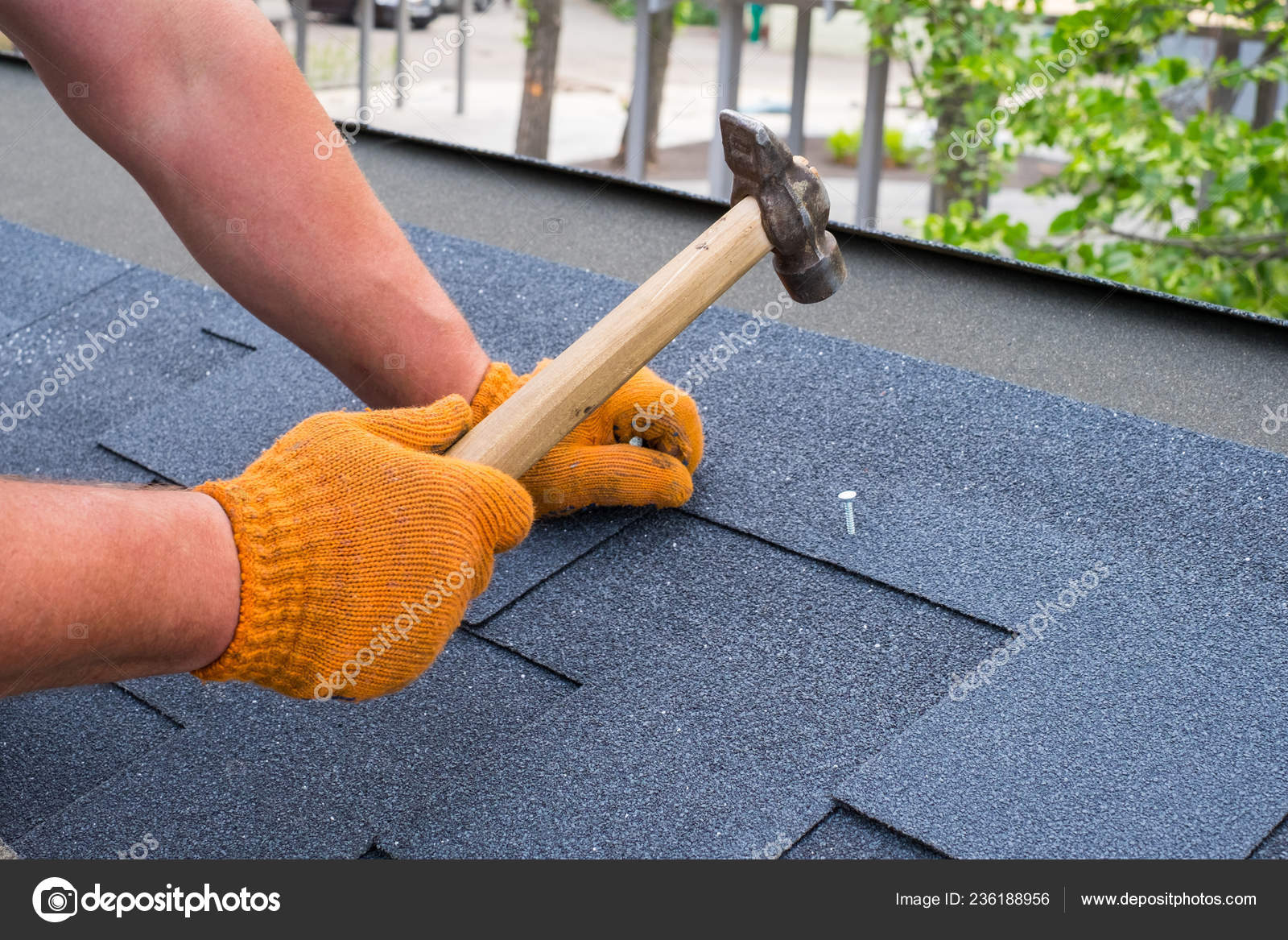 Workers Hands Installing Bitumen Roof Shingles Using Hammer Nails Stock