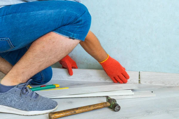 Trabajador Instala Zócalo Plástico Suelo Laminado Renovación Del Zócalo Casa —  Fotos de Stock