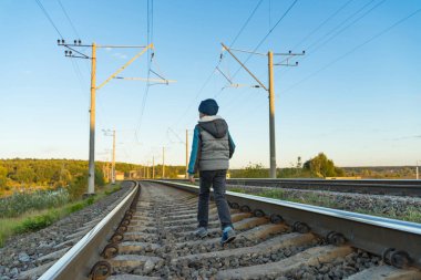 Küçük bir çocuk demiryolu üzerinde artan tehlike bir bölge yürümek.