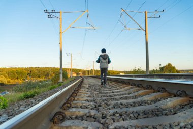 Küçük bir çocuk demiryolu üzerinde artan tehlike bir bölge yürümek. Seçici odaklı fotoğraf.