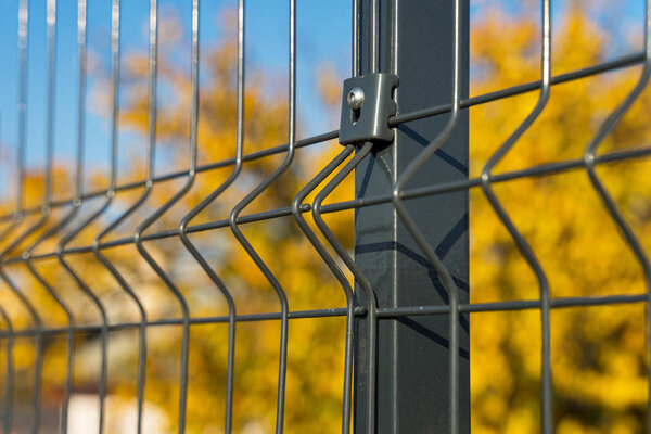 Steel grating fence made with wire on blue sky background. Sectional fencing installation
