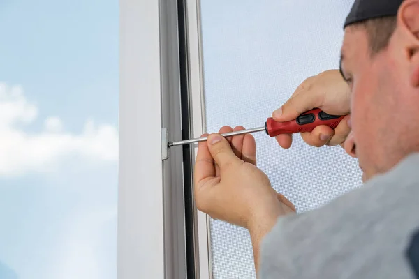 A contractor master adjusts and repair in house plastic windows.