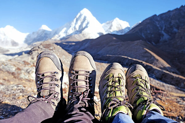 Hiker with backpacks reaches the summit of mountain peak. Success, freedom and happiness, achievement in mountains. Active sport concept.