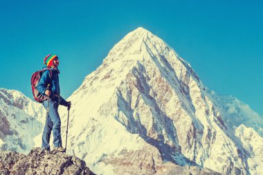 Sırt çantalı gezgin dağın zirvesine ulaşır. Başarı, özgürlük ve mutluluk, dağlarda başarı. Etkin spor konsepti.