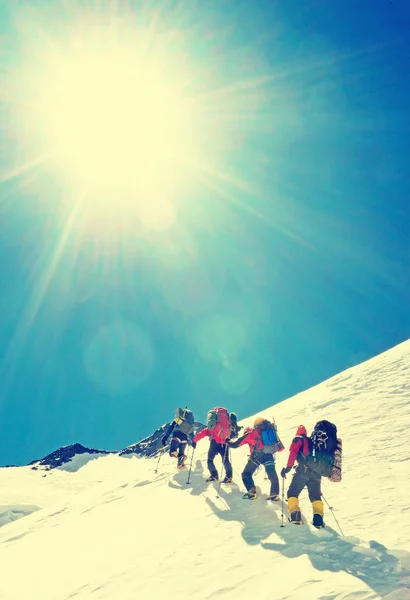 Grupo de alpinistas atinge o topo do pico da montanha. Escalada e esporte de alpinismo. Montanhas . — Fotografia de Stock