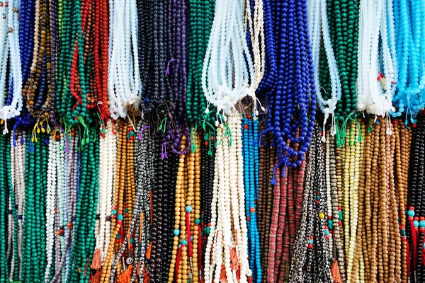 Les perles Rudraksha pendent sur le marché. Arrière-plan des perles Rudraksha. Collier de pierre de couleur artisanale sur le marché — Photo