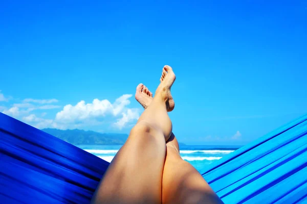 Junge Frau entspannt sich in der Hängematte am Sandstrand mit Blick auf abgelegene tropische Inseln. Urlaub und Urlaubskonzept. Tropenstrand. schöne tropische Insel. — Stockfoto