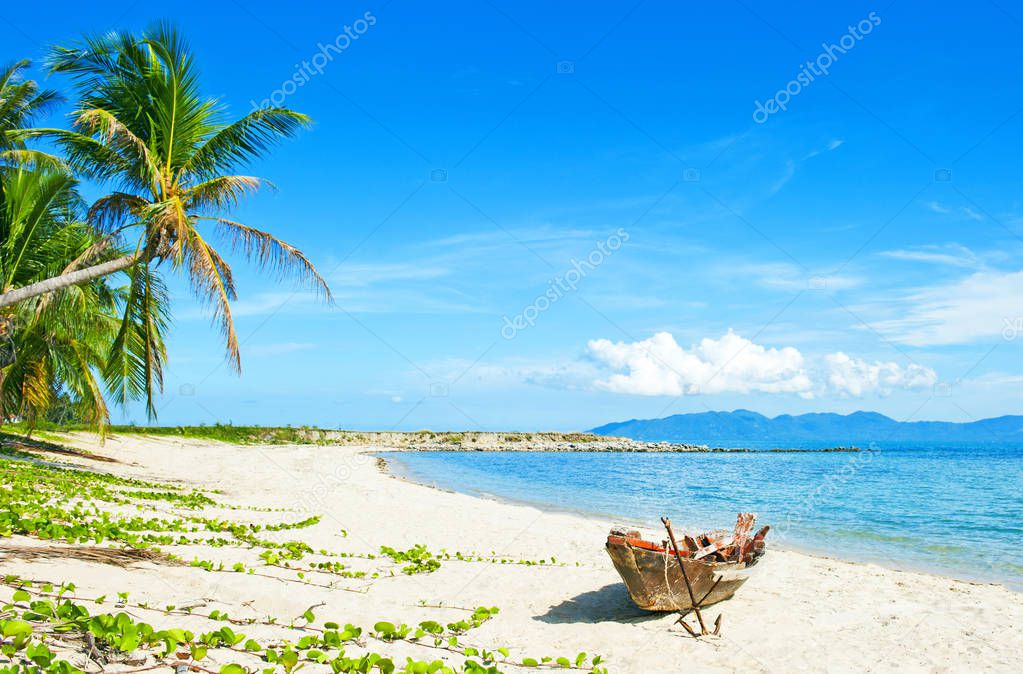 Old fisherman boat with anchor on the tropical palm beach. Tropical beach. Beautiful tropical island.