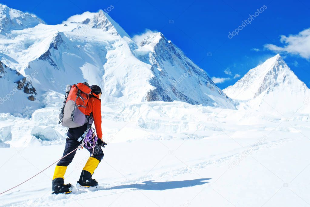 Group of climbers with backpacks reaches the summit of mountain peak. Success, freedom and happiness, achievement in mountains. Active sport concept.