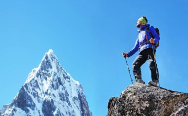 Sırt çantalı gezgin Nepal 'deki dağın zirvesine ulaşır. Etkin spor konsepti.