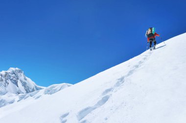 Dağcı, manzara manzarasının keyfini çıkarırken dağ zirvesinin zirvesine ulaşır. Başarı, özgürlük ve mutluluk, dağlarda başarı. Tırmanma sporu konsepti.