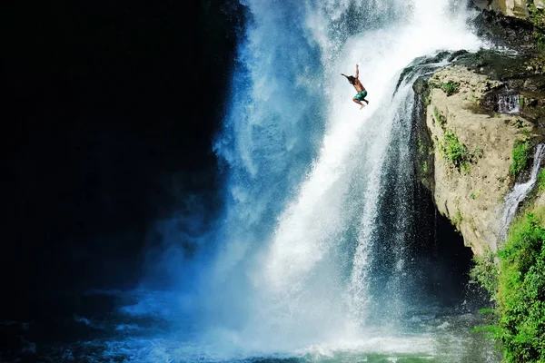 Saltar al agua. Hombre divirtiéndose en cascadas en la naturaleza. Bali, Indonesia — Foto de Stock