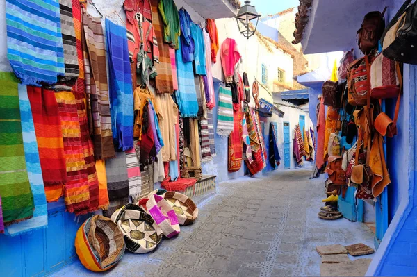 Moroccan handmade crafts, carpets and bags hanging in the narrow street of Essaouira in Morocco with selective focus