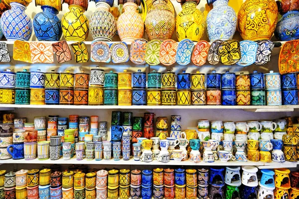 Moroccan handmade crafts, ceramic dishes and pots hanging in the narrow street of Essaouira in Morocco with selective focus