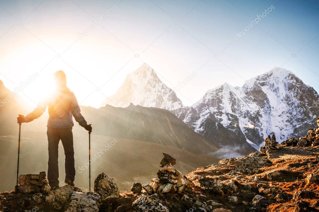 Hiker with backpacks reaches the summit of mountain peak. Success, freedom and happiness, achievement in mountains. Active sport concept.