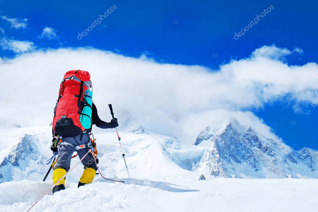 Group of climbers with backpacks reaches the summit of mountain peak. Success, freedom and happiness, achievement in mountains. Active sport concept.