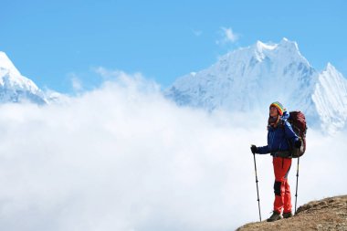 Sırt çantaları ile donatılmış kız yürüyüşçisi dağ zirvesinin zirvesine ulaşır. Başarı, özgürlük ve mutluluk, dağlarda başarı. Tırmanma spor konsepti
