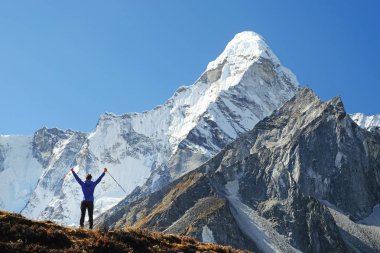 Dağcı, manzara manzarasının keyfini çıkarırken dağ zirvesinin zirvesine ulaşır. Başarı, özgürlük ve mutluluk, dağlarda başarı. Tırmanma sporu konsepti.