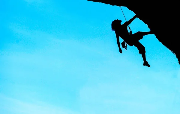 Silhueta de homem a escalar ao pôr do sol. Conceito de escalada — Fotografia de Stock