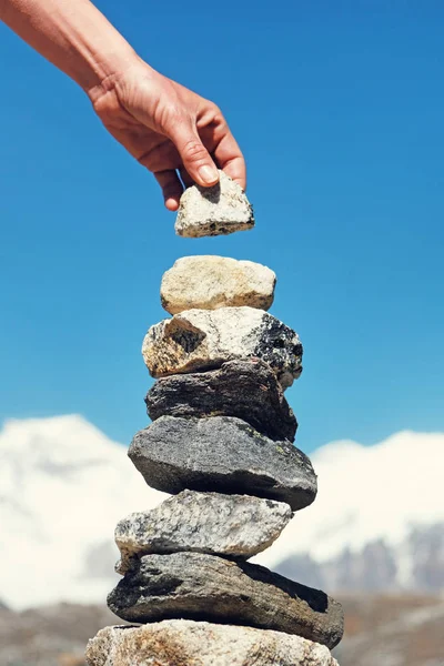 Ruční vytvoření kamenné věže. Něčí ruka konstruuje rovnováhu. — Stock fotografie