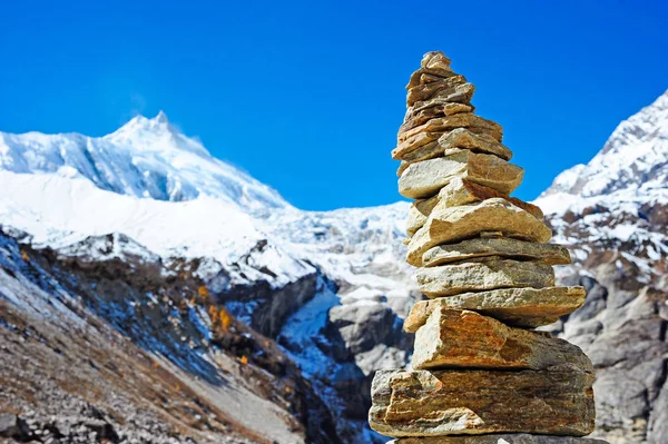 Pedras de seixo em um fundo de céu azul e pico de montanha de Manaslu. Conceito de equilíbrio e harmonia — Fotografia de Stock