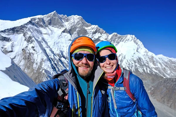 Two climbers reaches the summit of mountain peak. Success, freedom and happiness, achievement in mountains. Climbing sport concept.