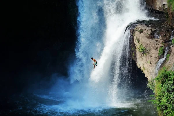 Saltar al agua. Hombre divirtiéndose en cascadas en el Bali — Foto de Stock