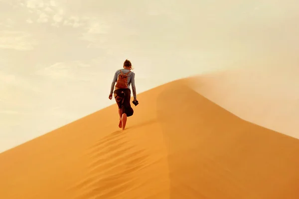 Meisje wandelen op zandduinen bij zonsondergang in de Sahara woestijn — Stockfoto