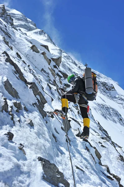 Utrustad klättraren uppstigning på toppen av toppen i snöiga alpina berg. Livvakt yrkesmässig man på arbetet i kickberg. — Stockfoto