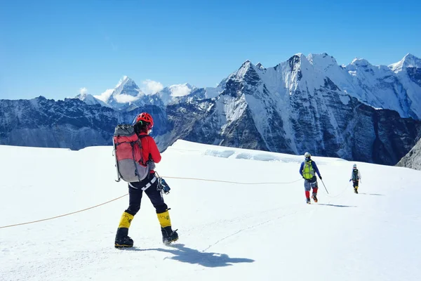 Alpinistas com mochila cruzando a fenda do glaciar Khumbu durante a subida no Everest — Fotografia de Stock