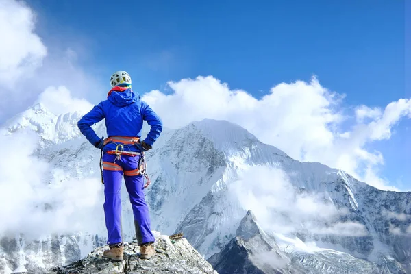 L'alpiniste atteint le sommet du sommet de la montagne en profitant de la vue sur le paysage . — Photo