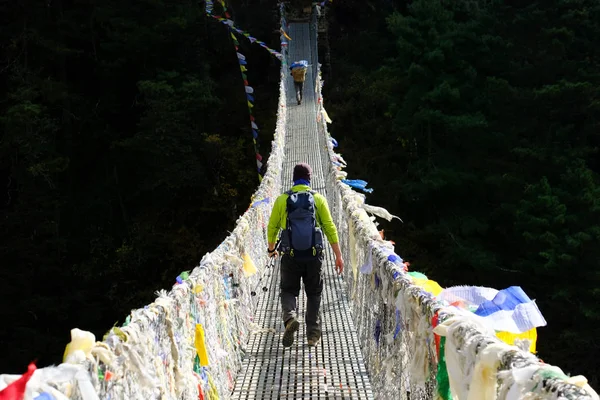 Trekker Nepal, Himalayalar metal asma köprü geçiş — Stok fotoğraf
