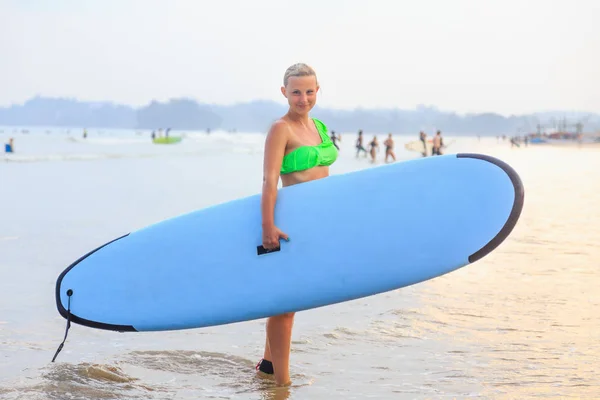 Mädchen mit blauem Surfbrett — Stockfoto