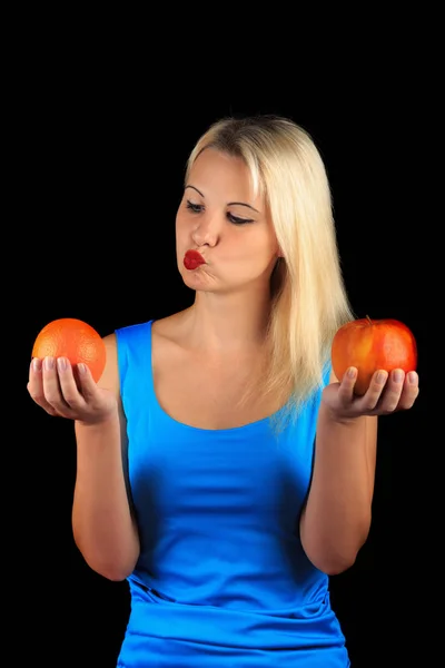 Menina segura em suas mãos e avalia Apple e laranja — Fotografia de Stock